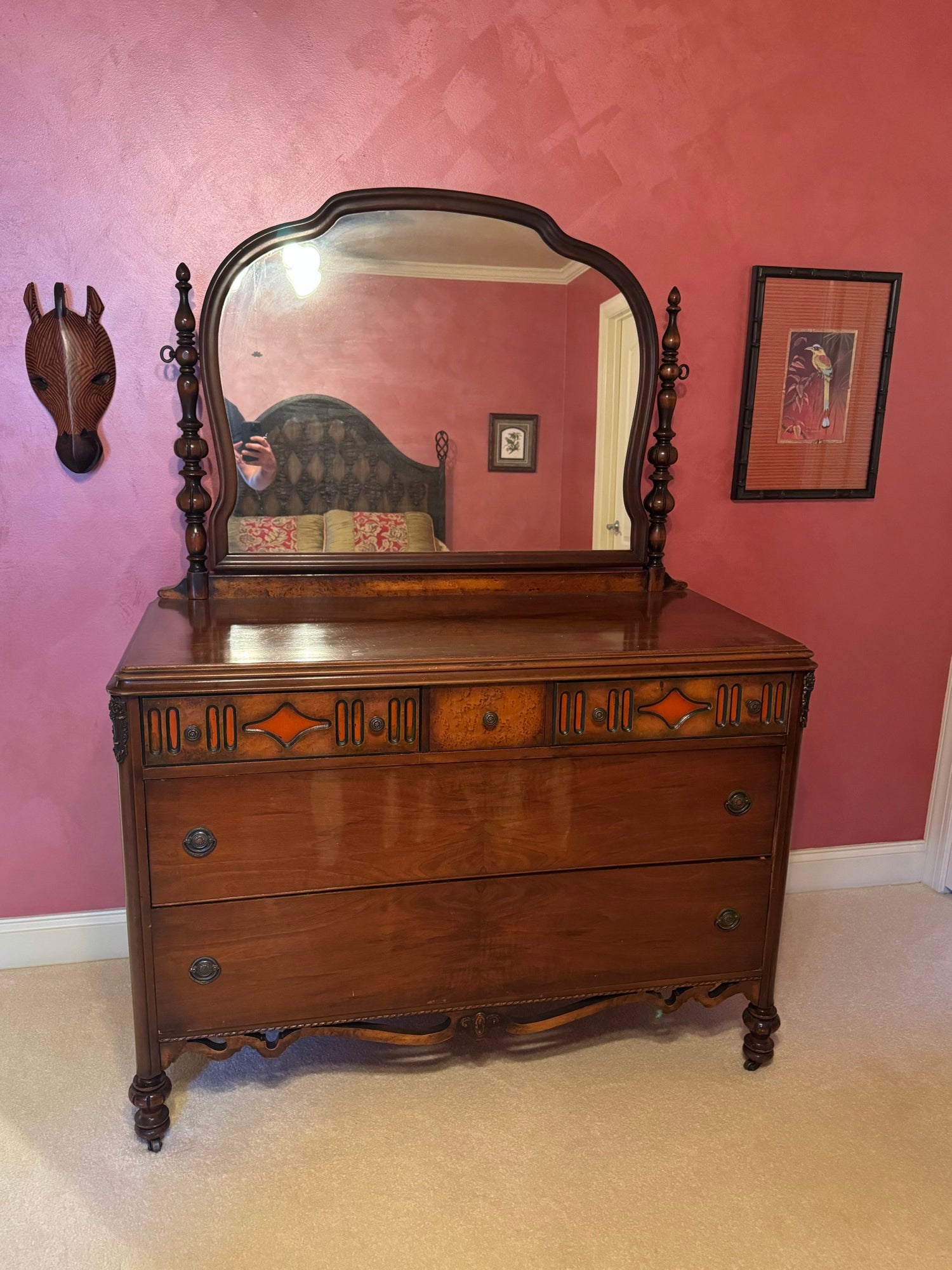 Antique walnut dresser with mirror viewed from front, showing decorative veneered drawer fronts with geometric inlay and turned finials