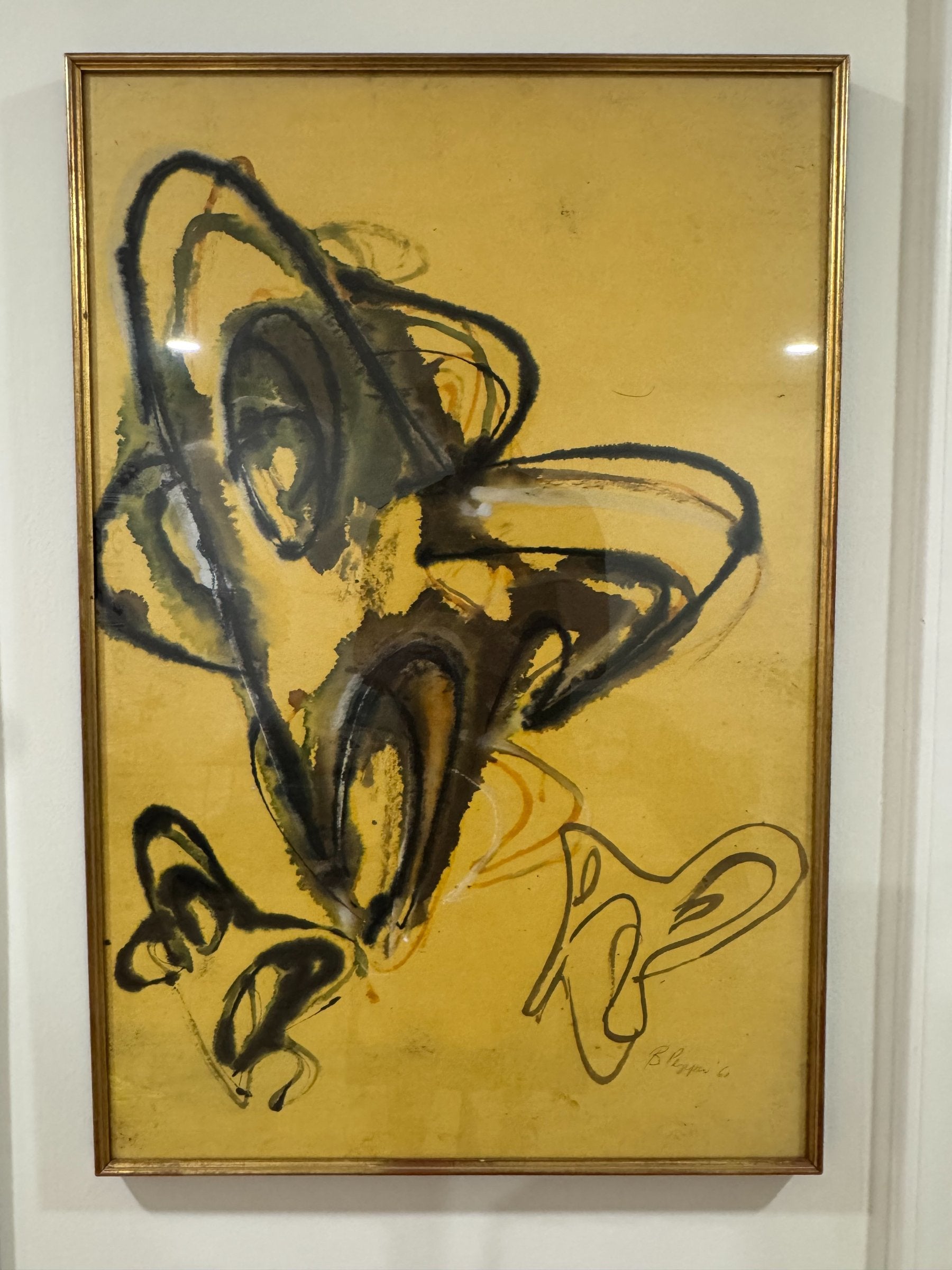 Framed abstract painting displayed on white wall, showing complete artwork with yellow background and gestural black mark-making