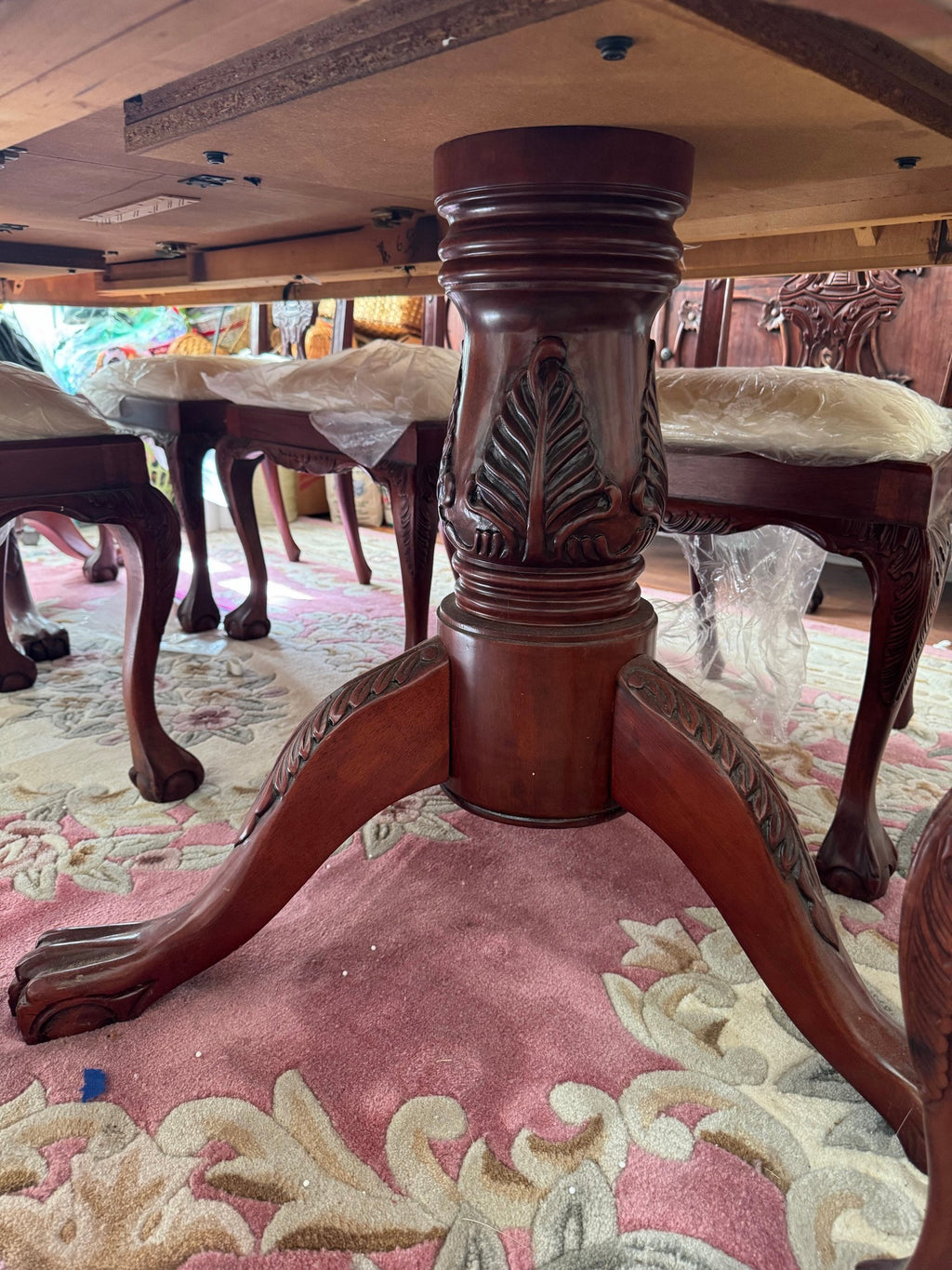 Carved pedestal base of the dining table with ball-and-claw feet
