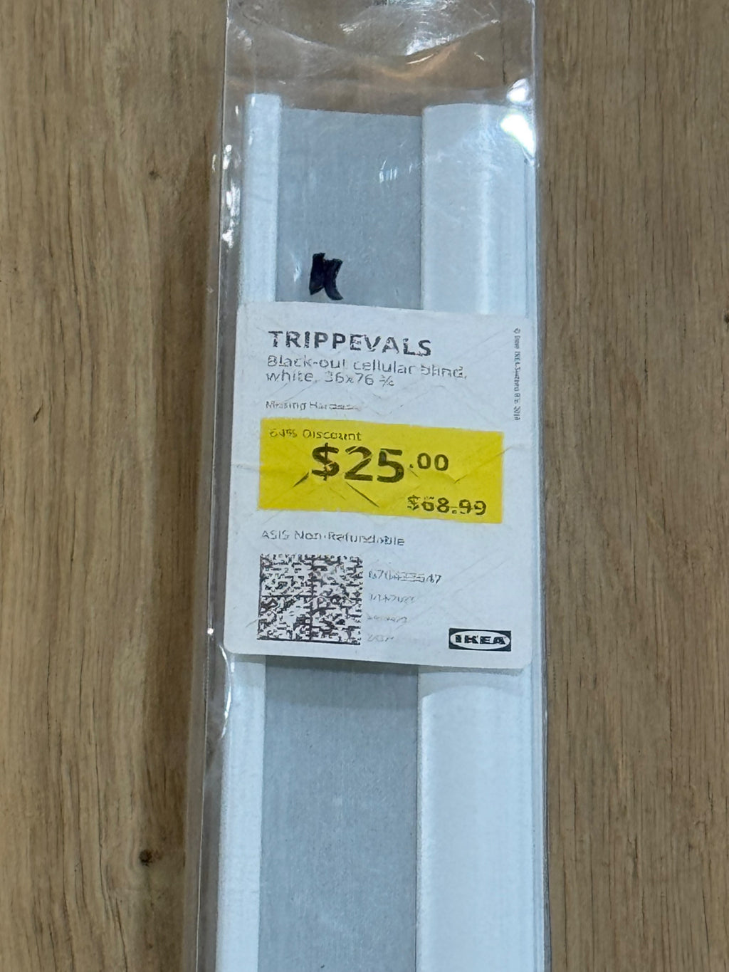 Close-up of product label showing brand name, product details, price of $25.00 discounted from $58.99, and QR code