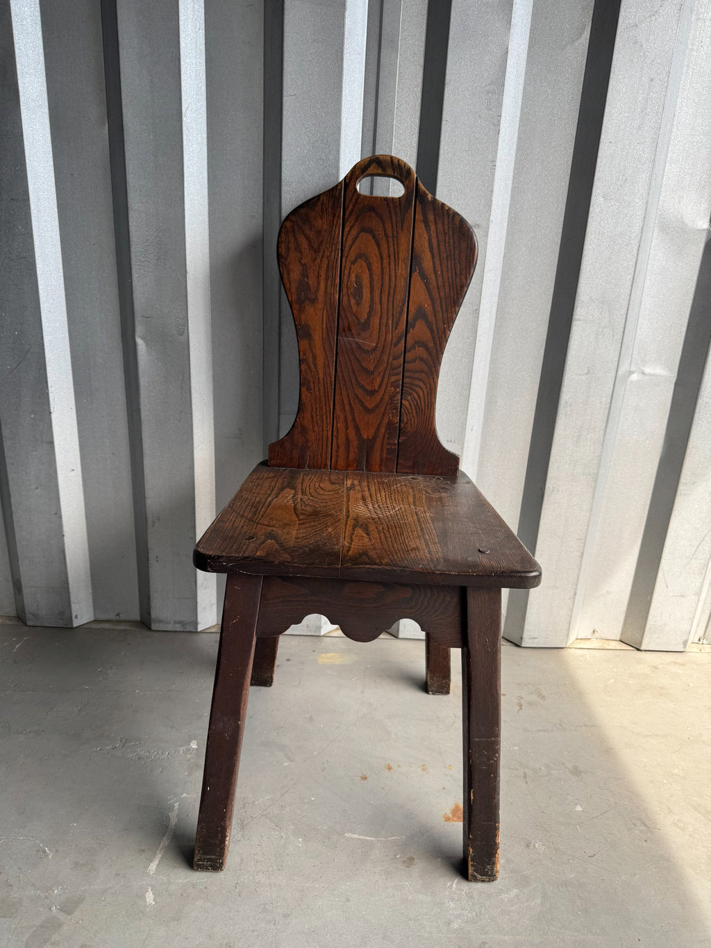 Chair from side angle showing leg construction and curved seat profile