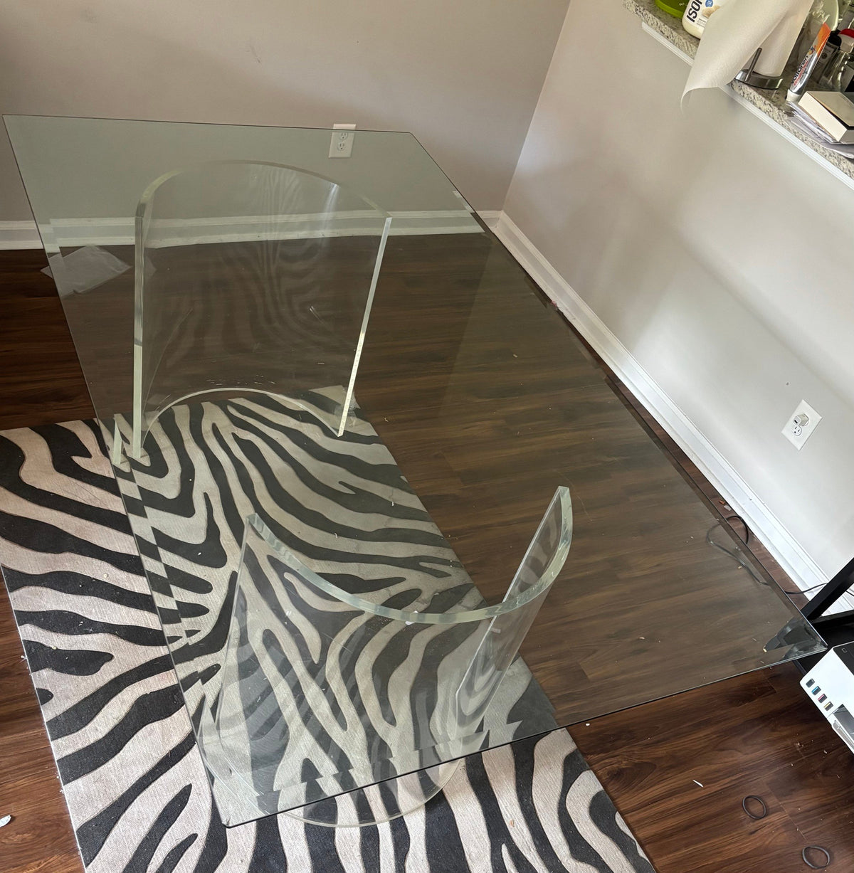 Rectangular glass dining table on curved clear acrylic bases, from above