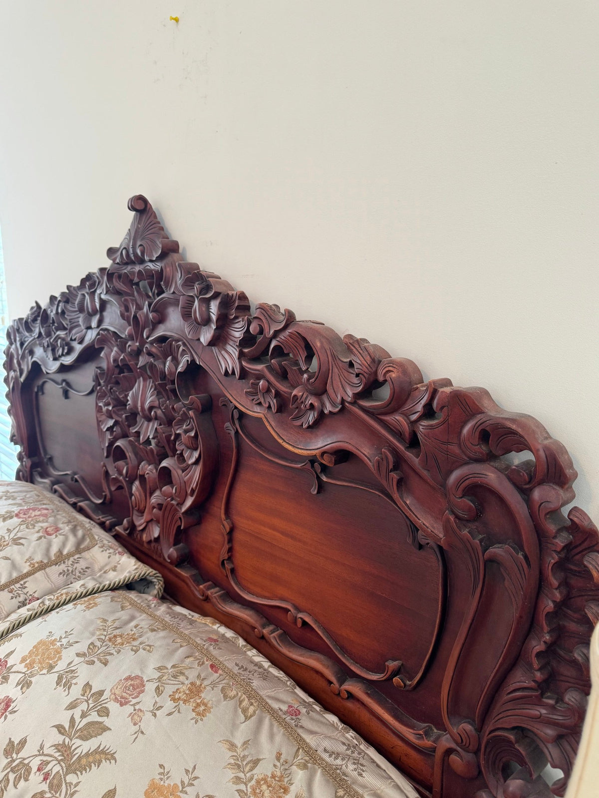Headboard seen at an angle showing relief carving and flat panel