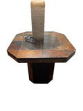 Octagonal side table with multi-tone rust and black slate tile top and black pedestal base, shown with a lamp base and eyeglasses on top