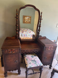 Antique walnut vanity with swing mirror, two pedestals with cabinet doors, and upholstered bench seat