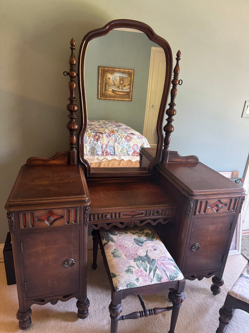 Antique walnut vanity with swing mirror, two pedestals with cabinet doors, and upholstered bench seat