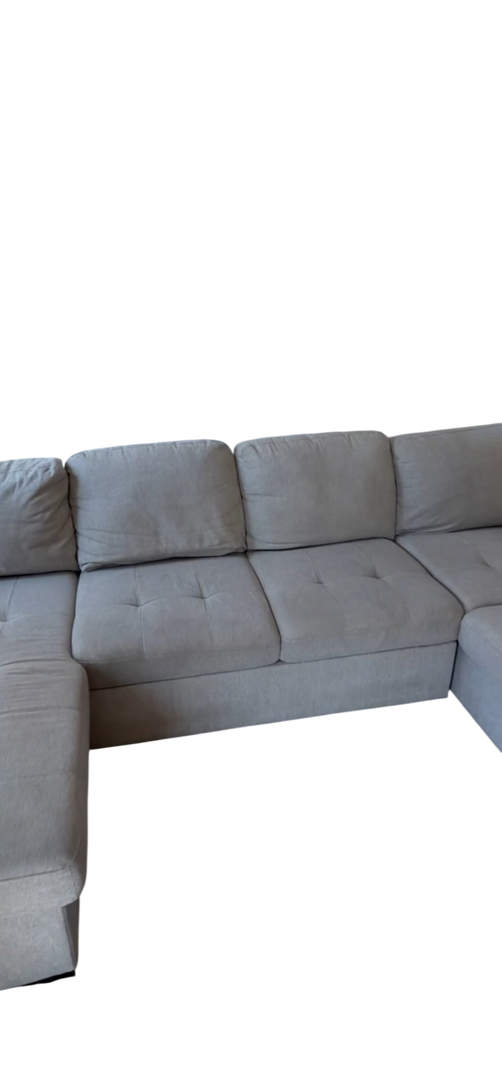 Gray upholstered L-shaped sectional sofa with tufted seat cushions, shown from side angle
