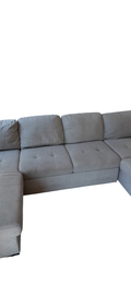 Gray upholstered L-shaped sectional sofa with tufted seat cushions, shown from side angle
