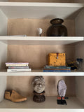 Shelves with amethyst cluster, carved head, shoe last and books