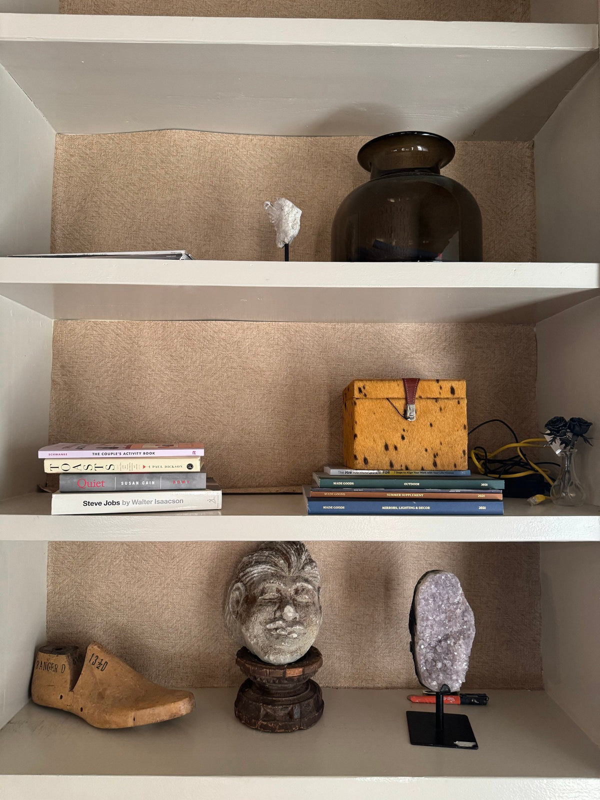 Shelves with amethyst cluster, carved head, shoe last and books