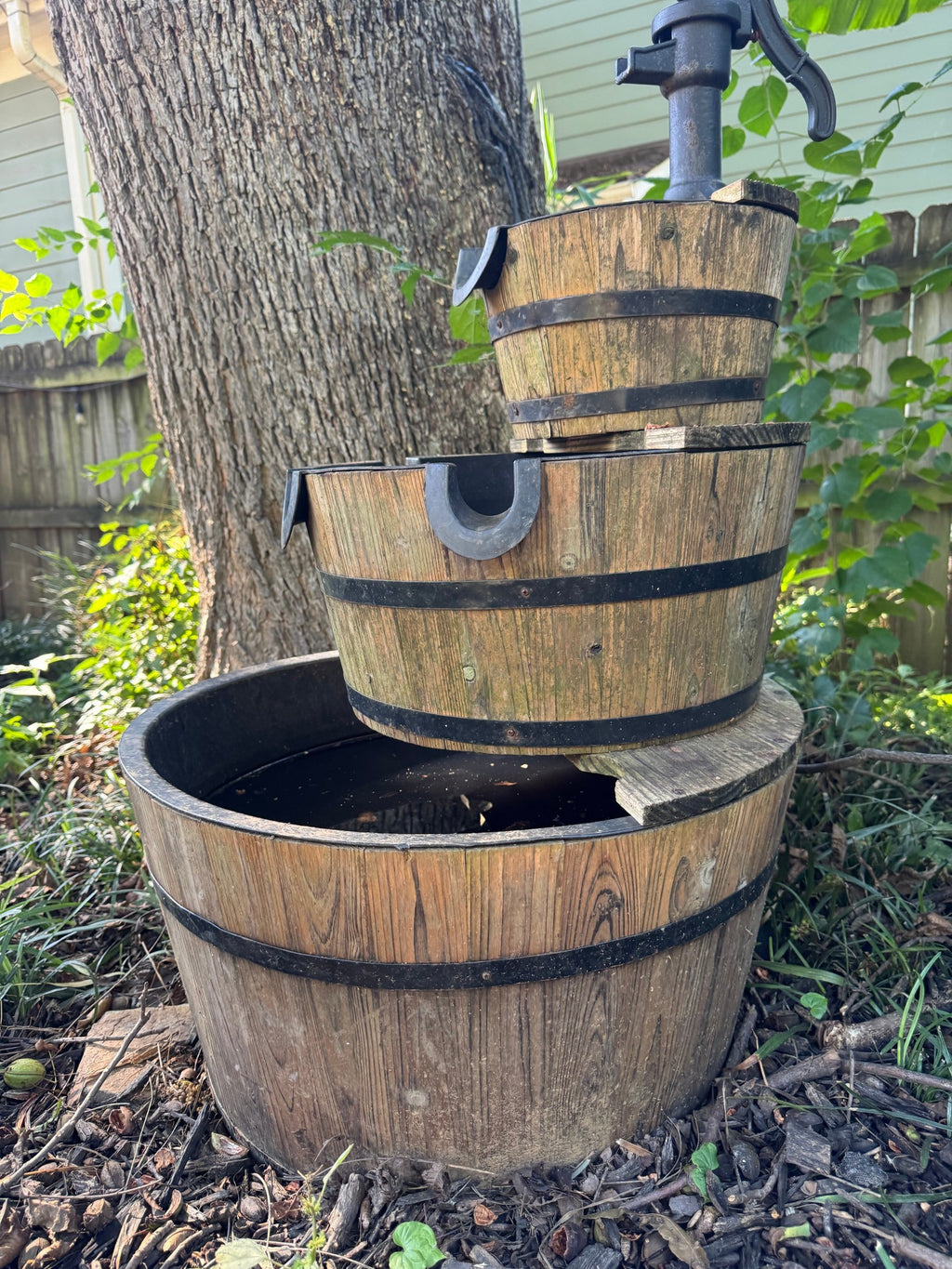 Side view of the stacked half-barrel tiers with black metal banding and water basins