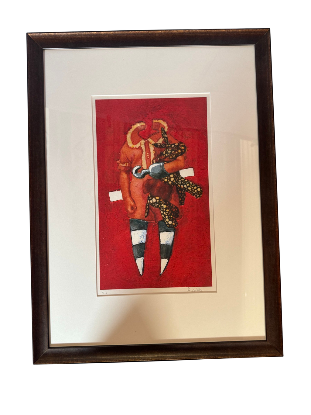 Framed red print with a hook-handed figure, straight-on