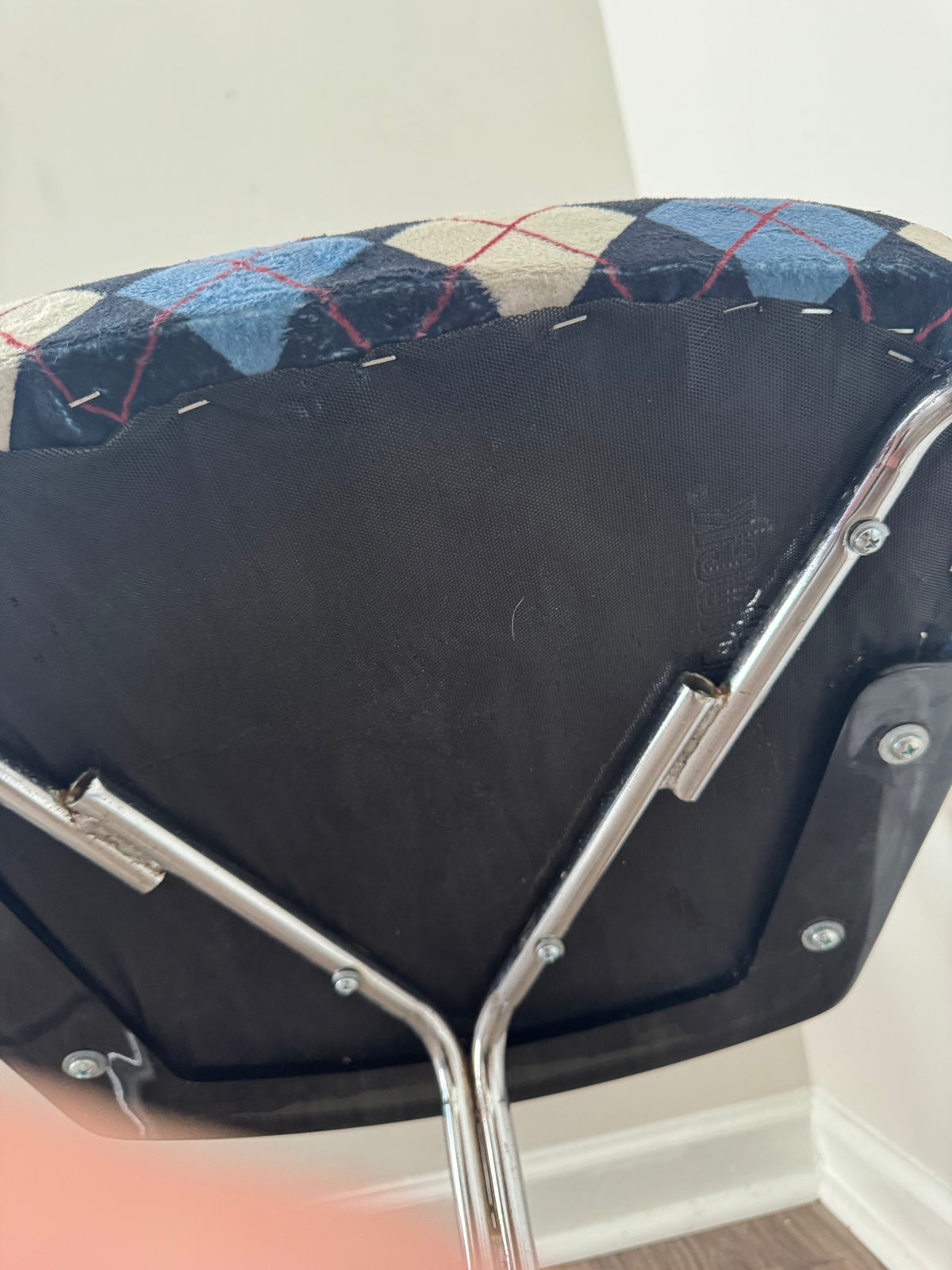 Close-up detail of seat cushion showing navy, cream and light blue argyle pattern with red thread lines and black underside fabric
